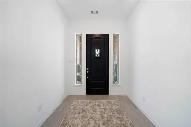 a view of an empty room with closet and entryway