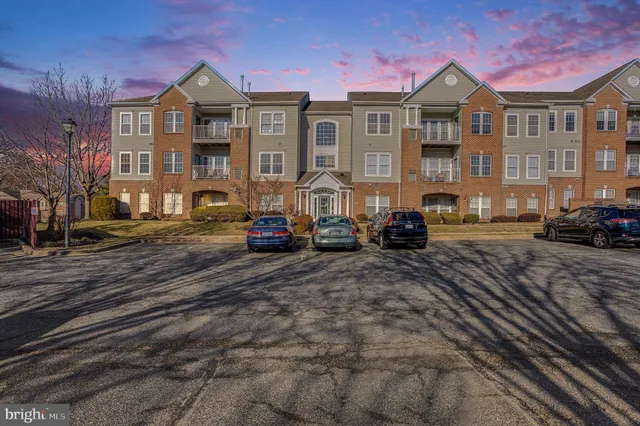 a front view of a house with cars parked