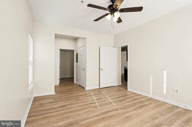 a view of a room with wooden floor and ceiling fan