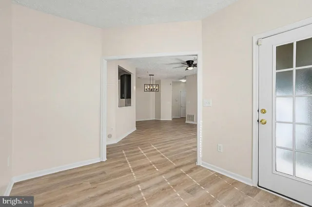 a view of a hallway with wooden floor and closet