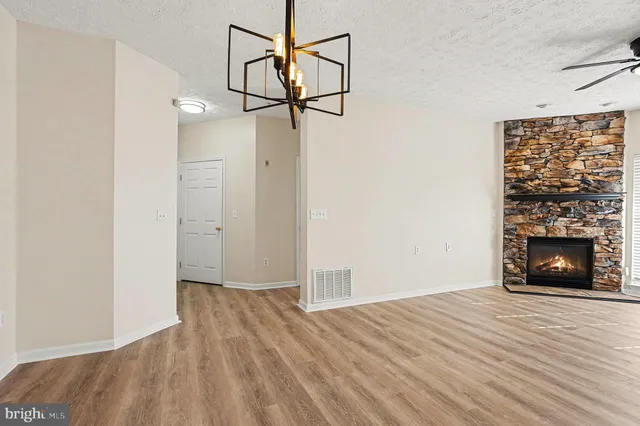 a view of empty room with wooden floor and fireplace