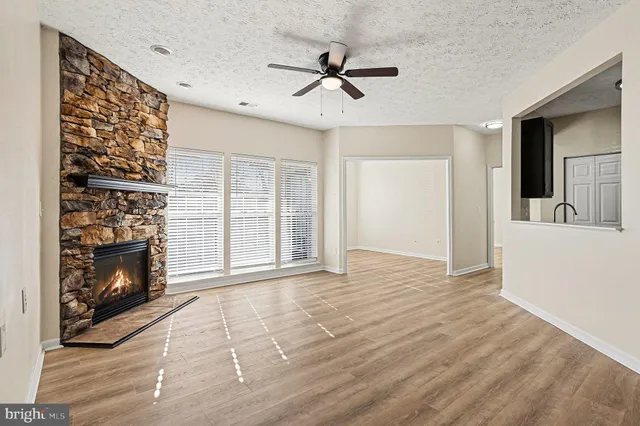 a view of an empty room with a fireplace and a window