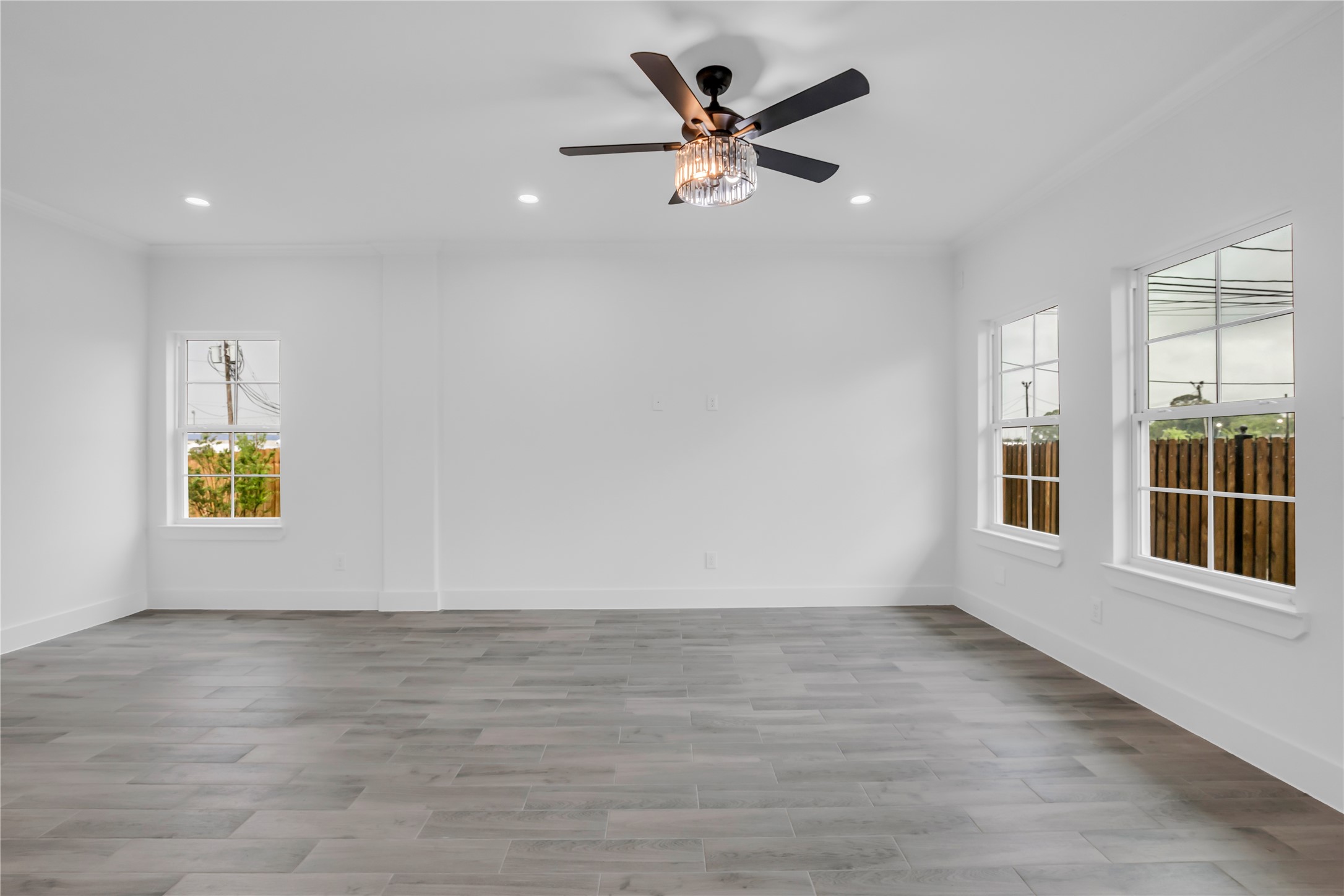 3168 Golfcrest Houston, TX 77087 - Photo 17 of 30 This inviting living room boasts abundant natural light, elegant wood-style flooring, and a modern ceiling fan, offering a perfect blend of comfort and style for your dream home.