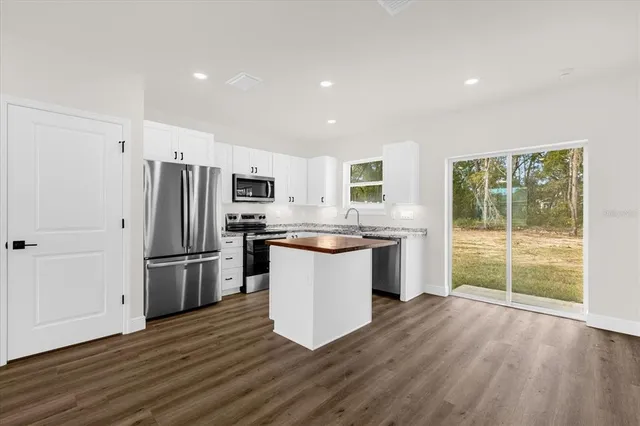 a kitchen with a refrigerator and wooden floor