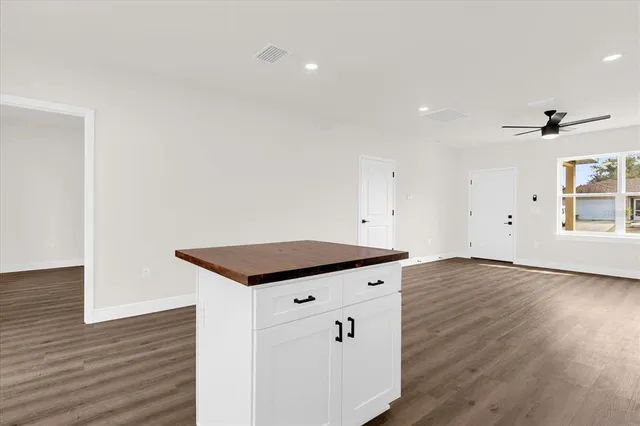 a kitchen with granite countertop a stove and a wooden floor