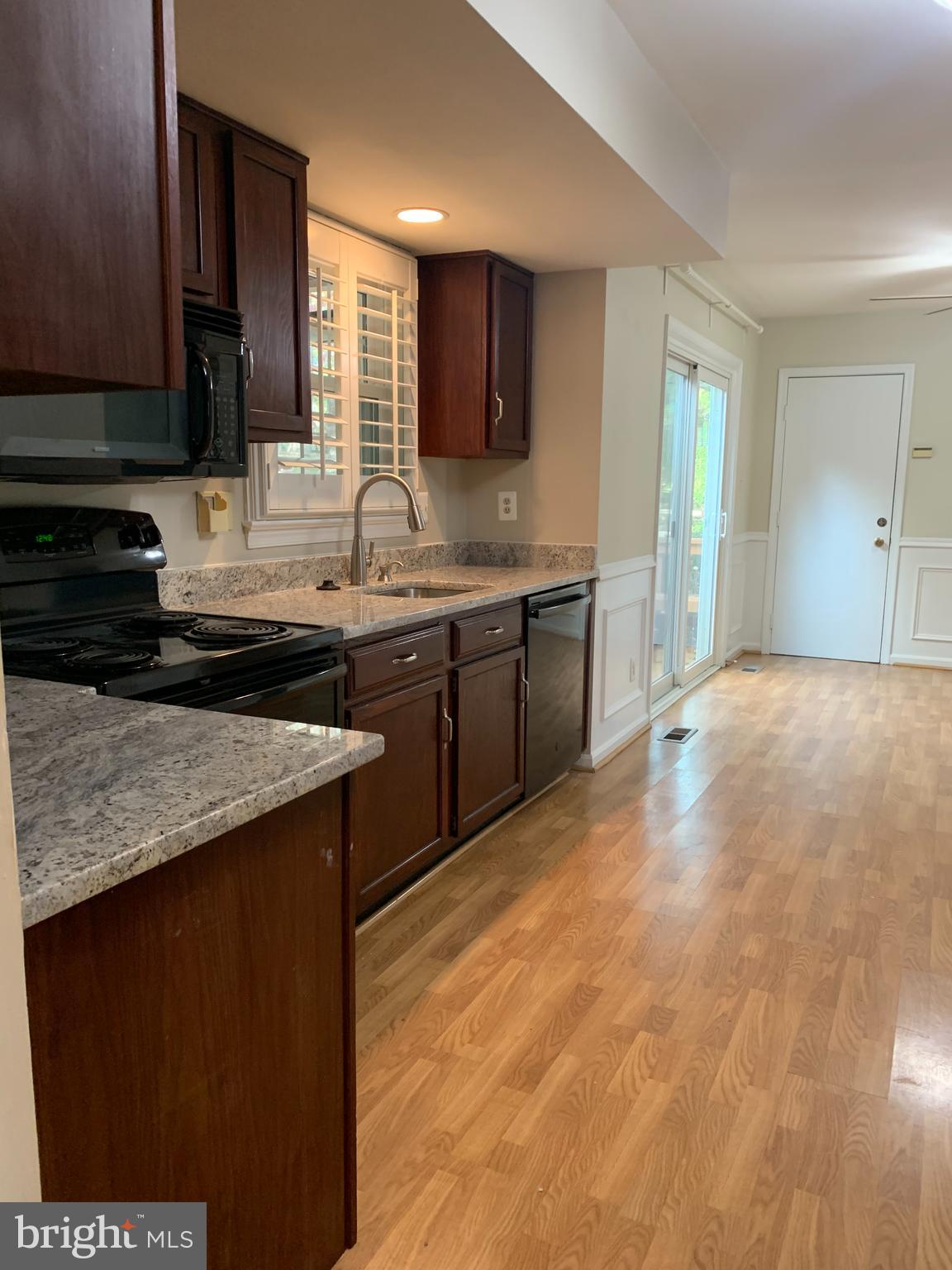 5606 Light Infantry Drive Burke, VA 22015 - Photo 18 of 66 a kitchen with stainless steel appliances granite countertop a sink stove and cabinets