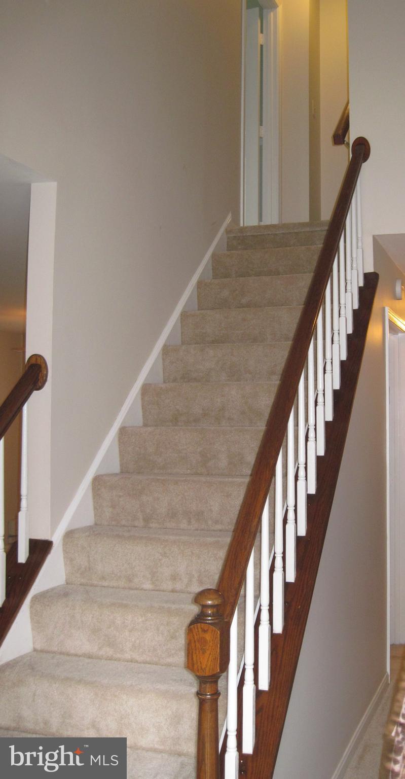 5606 Light Infantry Drive Burke, VA 22015 - Photo 25 of 66 a view of staircase with lots of frames on wall and wooden floor