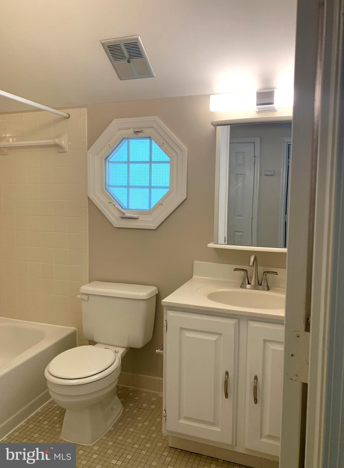 5606 Light Infantry Drive Burke, VA 22015 - Photo 35 of 66 a bathroom with a toilet a sink and mirror