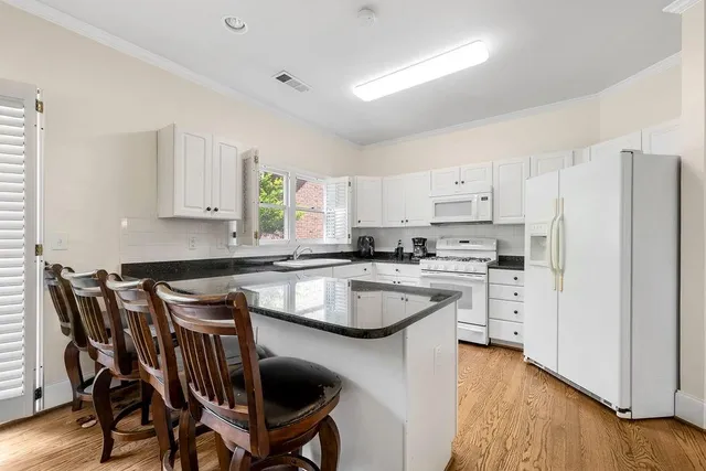 a kitchen with stainless steel appliances granite countertop a white cabinets and a stove top oven