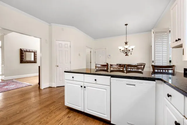 a kitchen with granite countertop white cabinets and white appliances