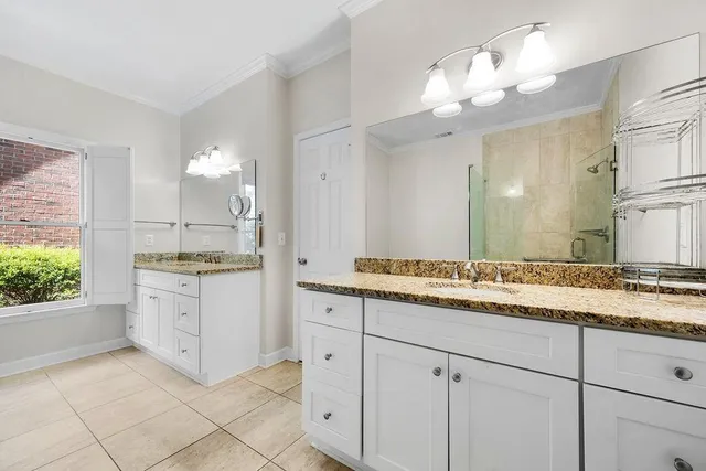 a bathroom with a granite countertop sink mirror and cabinets