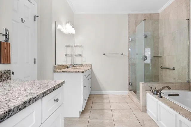 a bathroom with a granite countertop sink a mirror and a bathtub