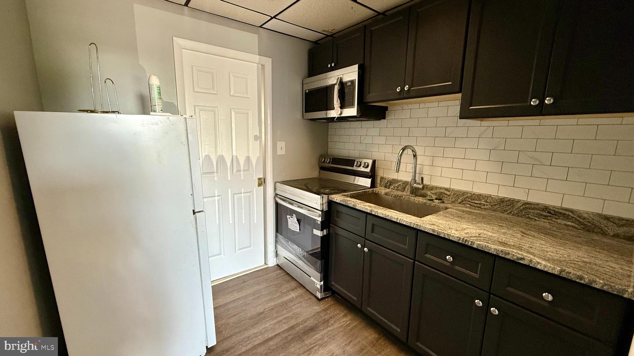 5910 Hamilton Avenue, Unit 3 Baltimore, MD 21237 - Photo 1 of 5 a kitchen with a sink a stove and refrigerator