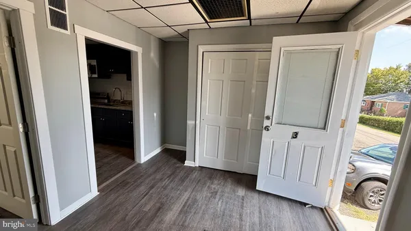 a view of a hallway with wooden floor and cabinet