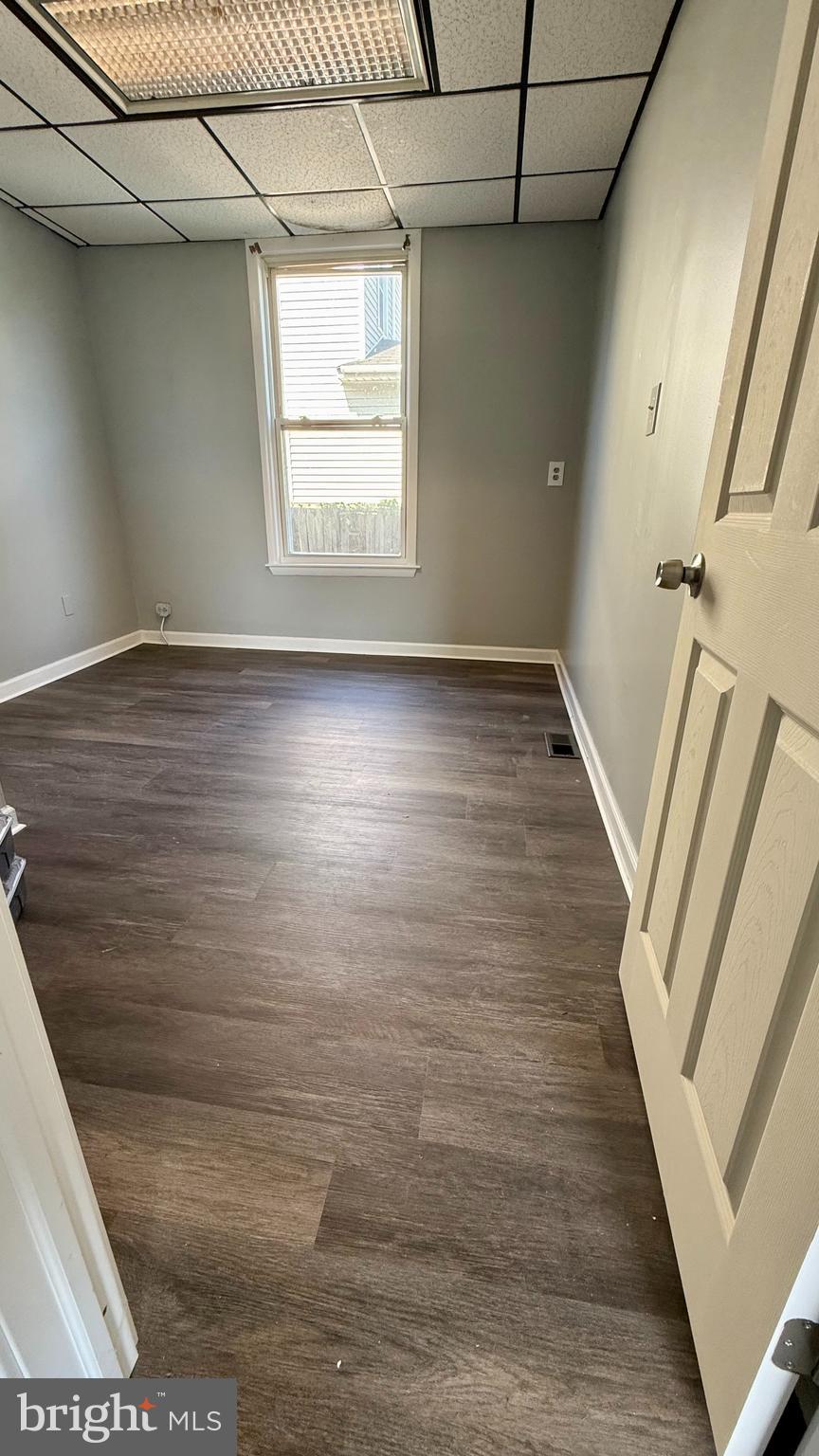 5910 Hamilton Avenue, Unit 3 Baltimore, MD 21237 - Photo 4 of 5 a view of an empty room with wooden floor and a window