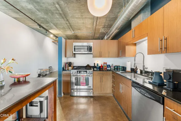 a kitchen with stainless steel appliances granite countertop a sink a stove and cabinets
