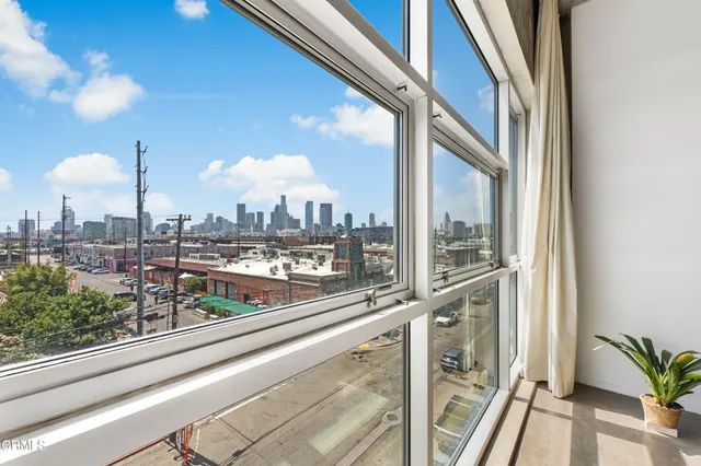 a living room with furniture a rug and a floor to ceiling window