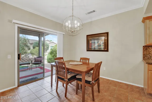 a dining room with furniture a rug and a floor to ceiling window