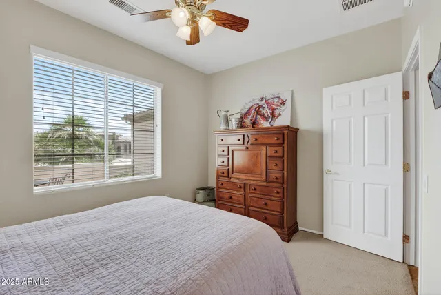 a bedroom with a dresser and a chandelier