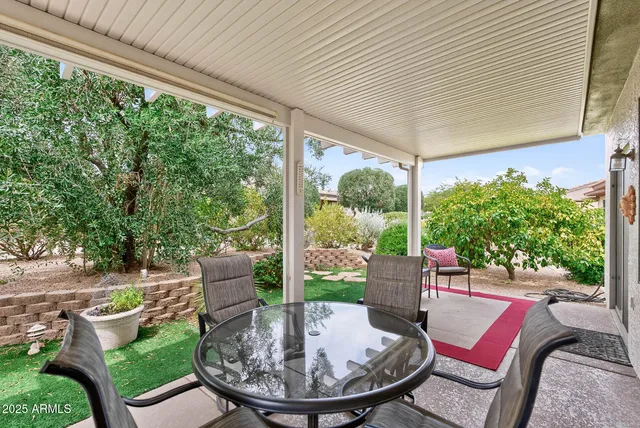 a view of a patio with a table chairs and a backyard