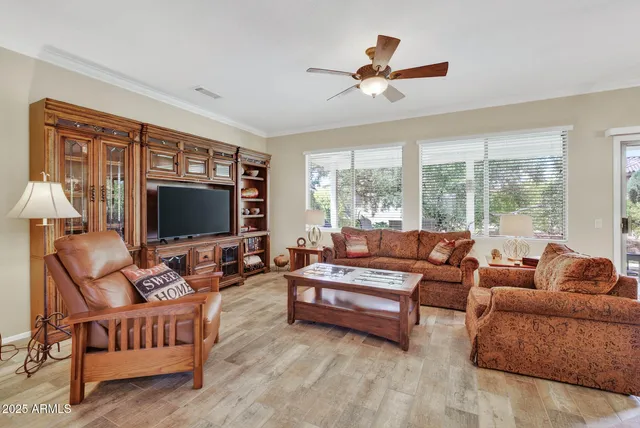 a living room with furniture ceiling fan and a flat screen tv