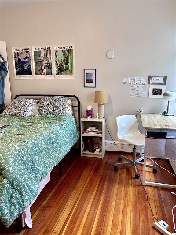805 Washington Street, Unit 2 Brookline, MA 02446 - Photo 10 of 20 a bedroom with a bed and wooden floor