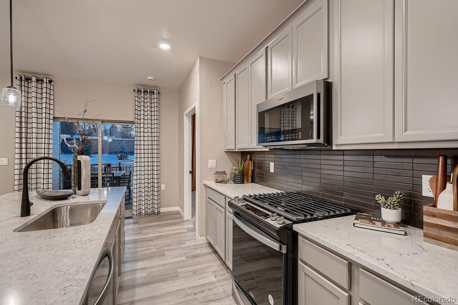 12880 Inca Street Westminster, CO 80234 - Photo 21 of 50 a kitchen with granite countertop a sink stainless steel appliances and cabinets