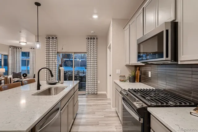 a kitchen with kitchen island a sink appliances and cabinets
