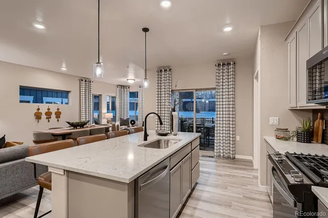 a kitchen with sink a stove and chairs