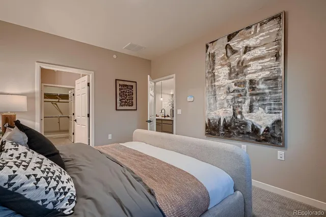 a bedroom with a bed and a painting on the wall