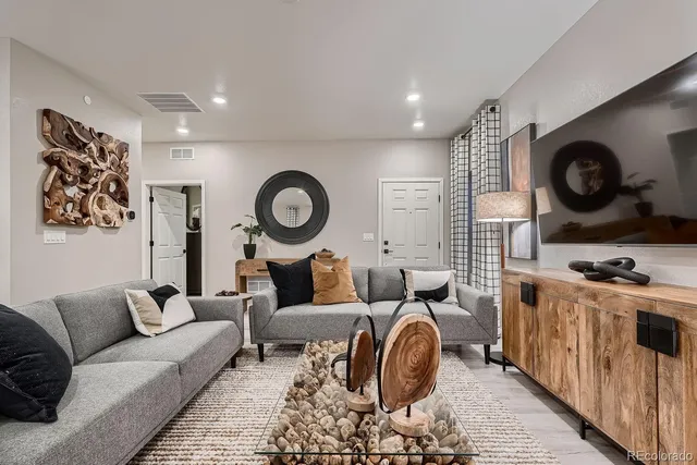 a living room with furniture a clock and a window
