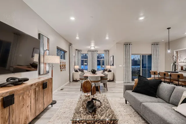 a living room with furniture flat screen tv and large window