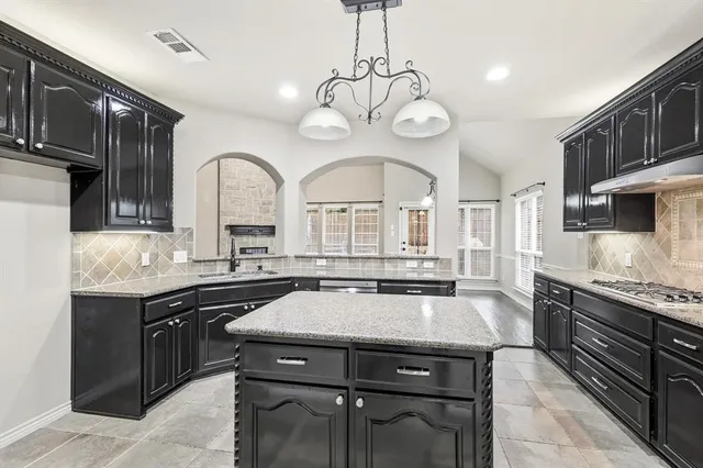 a kitchen with a stove center island and cabinets
