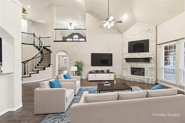 a living room with furniture a flat screen tv and a fireplace
