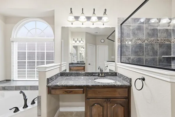 a bathroom with a granite countertop sink and a mirror