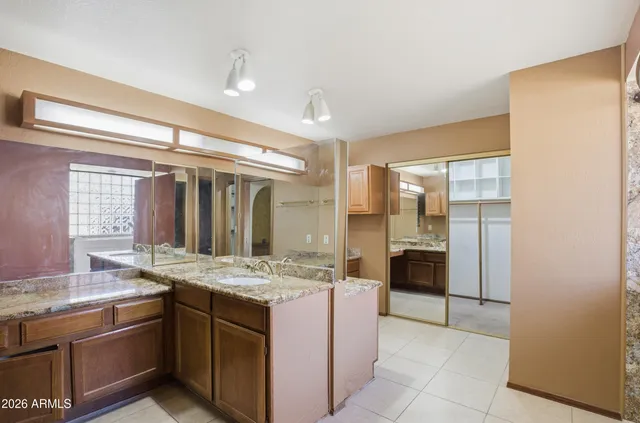 a bathroom with a granite countertop sink and a mirror