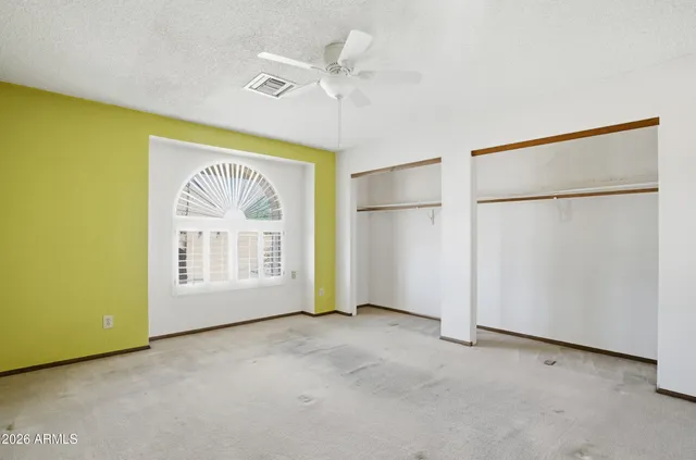 an empty room with windows and closet