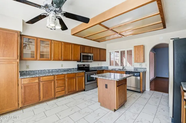 a kitchen with stainless steel appliances granite countertop a sink and a refrigerator