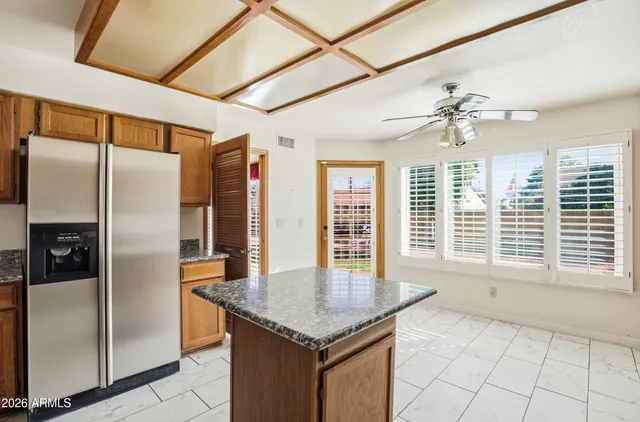 a kitchen with stainless steel appliances granite countertop a refrigerator a sink and a counter top space