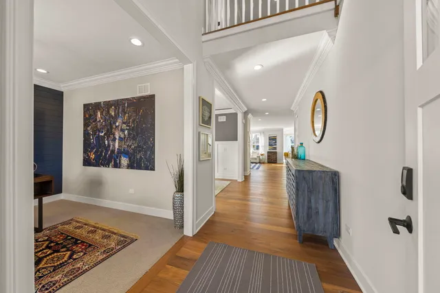 a view of a hallway with wooden floor and staircase