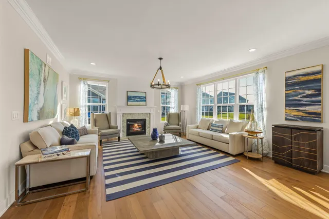 a living room with fireplace furniture and a large window