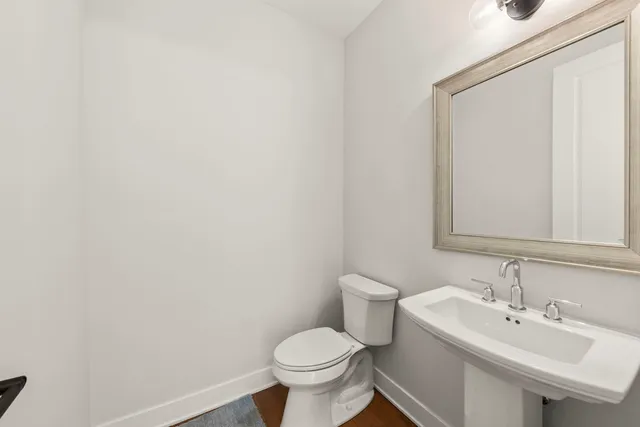 a bathroom with a sink toilet and a mirror