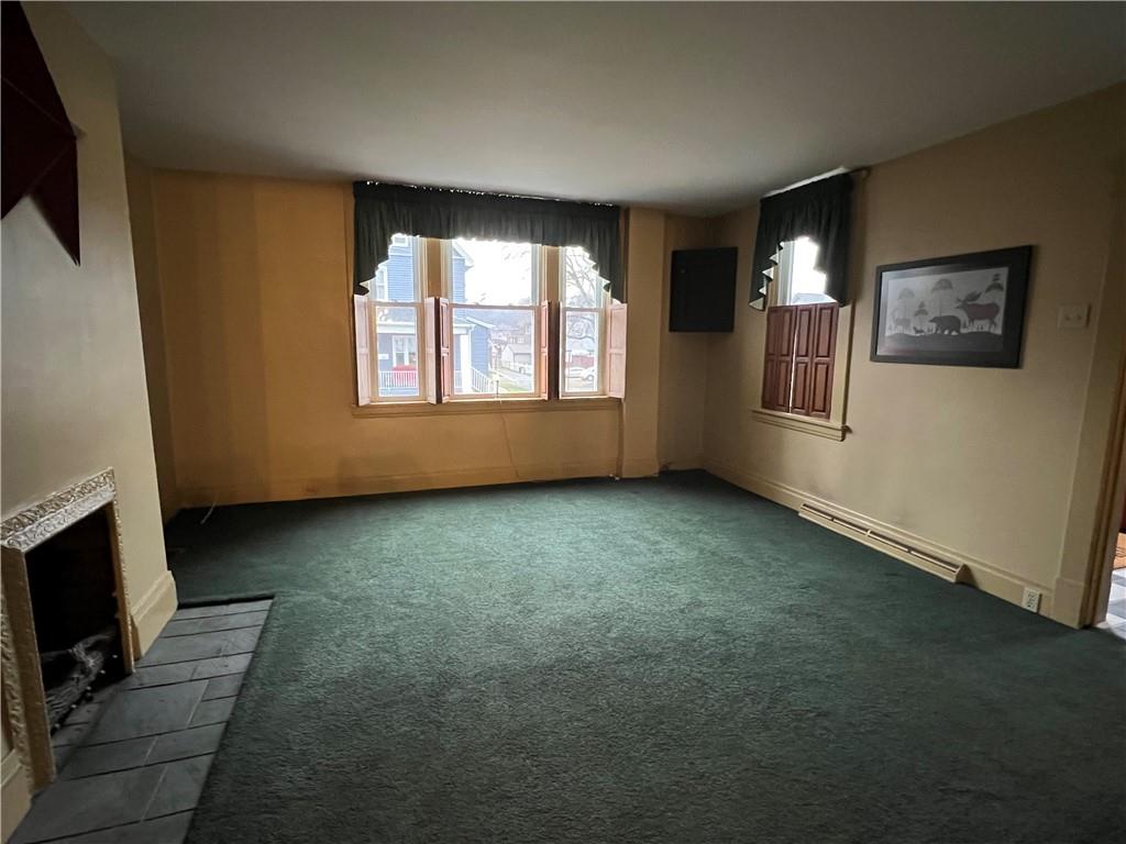 481 Heller Street Rochester, PA 15074 - Photo 9 of 24 an empty room with windows fireplace and wooden floor