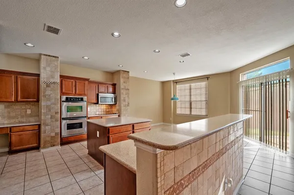 a large kitchen with kitchen island a sink counter space and stainless steel appliances