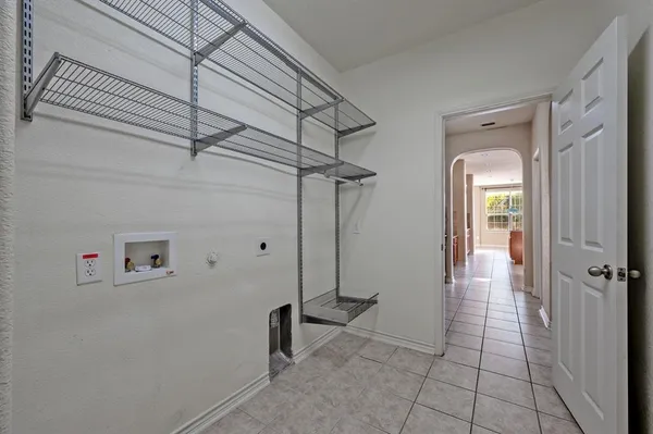 a view of a hallway with wooden floor and a chandelier