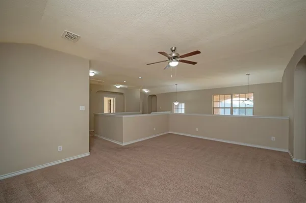 a view of an empty room with a chandelier fan