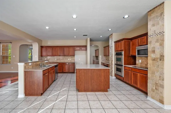 a kitchen with stainless steel appliances granite countertop a stove and a refrigerator