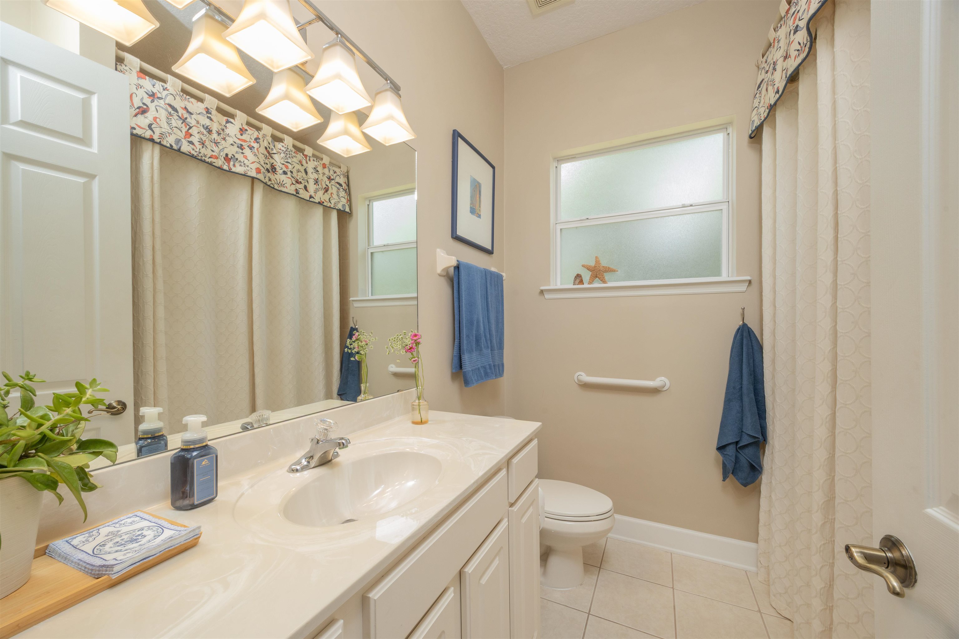 1160 Inverness Drive St. Augustine, FL 32092 - Photo 46 of 77 a bathroom with a granite countertop sink a toilet a mirror and shower