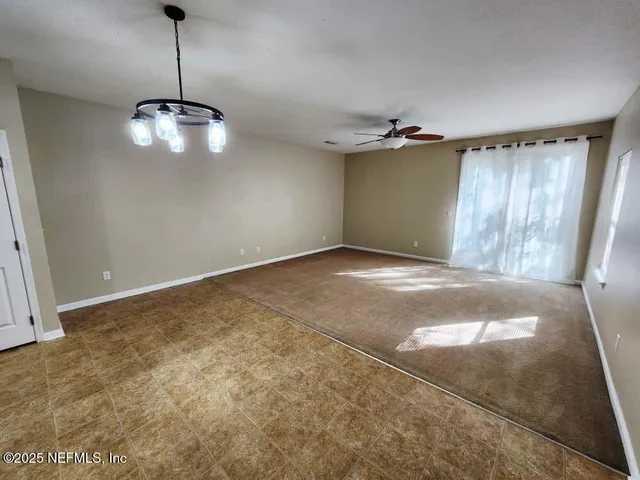 an empty room with a ceiling fan and window