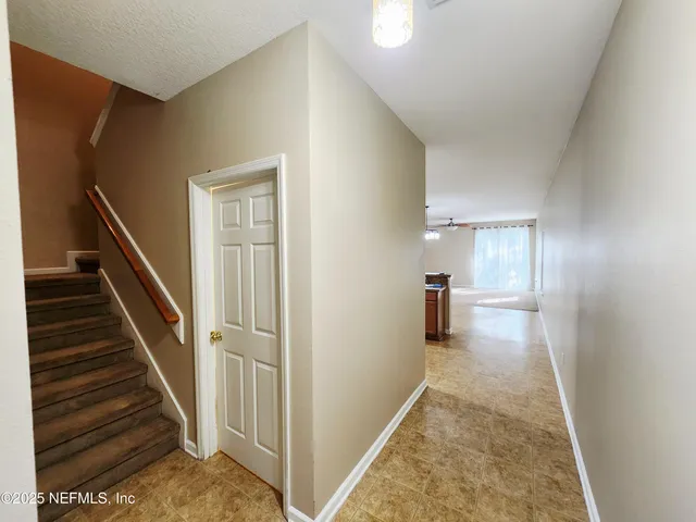 a view of a hallway with wooden floor and staircase